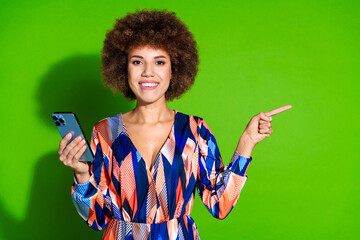 Canvas Print - Photo of funny cute cheerful woman wear trendy clothes recommend empty space isolated on vibrant green color background