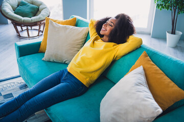 Wall Mural - Photo of attractive lovely pretty girl sitting on sofa arms behind head enjoying vacation in comfy room