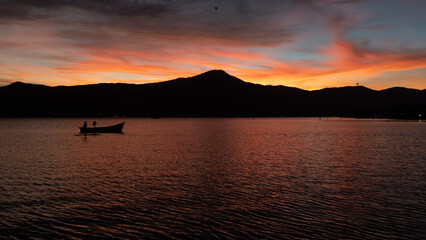 Wall Mural - Barco Pôr do Sol Céu Colorido Vermelho Laranja Lagoa da Conceição Floripa Florianópolis Paisagem Natural Reflexo Água Beleza Tranquilidade Natureza Final de Tarde Cenário Deslumbrante Floripa Brilho