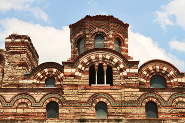 The upper facade of the Church of Christ Pantocrator in the old town of Nessebar, Nesebar, elaborate patterns out of bricks and colorful tiles, windows and the roof, Bulgaria