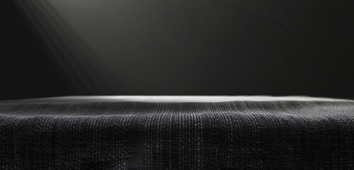 Black background with a gray table in the foreground, illuminated by soft light from above texture of fabric and a soft glow that adds depth to the composition Generative AI