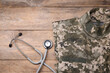 © New Africa - Stethoscope and military uniform on wooden background, flat lay