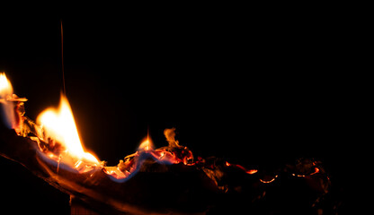 Wall Mural - burning paper, glowing edge of paper on a black background.