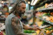 © Dina - hipster man with long gray hair and tattoos shopping for food at supermarket