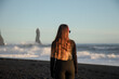 © ADDICTIVE STOCK - Woman overlooking sea stacks on Iceland black sand beach