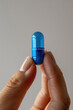 © ADDICTIVE STOCK - Close-up of a blue pill with Resilience text in hand. Generative AI image