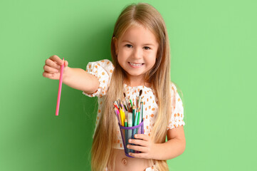 Poster - Cute little girl with pen cup on green background