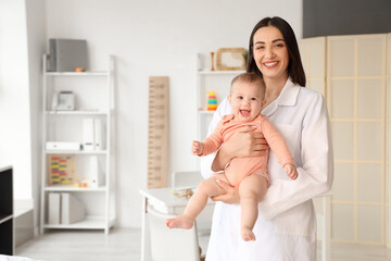 Wall Mural - Portrait of female pediatrician with little baby in clinic