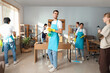 © Pixel-Shot - Group of janitors cleaning in office