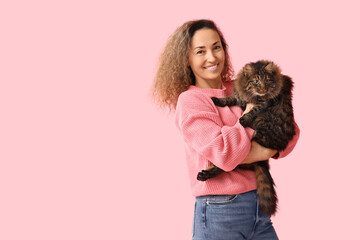 Wall Mural - Happy mature woman with cute cat on pink background