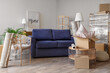 © Pixel-Shot - Cardboard boxes, sofa and furniture in new living room on moving day
