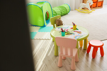 Poster - Interior of playroom with drawings on table in kindergarten