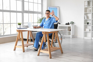 Poster - Young male doctor in wheelchair working at his workspace in clinic