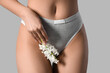 © Pixel-Shot - Beautiful young woman in panties with hyacinth flowers on grey background, closeup