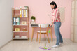 © Pixel-Shot - Pretty young woman mopping floor at home
