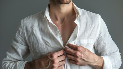 cropped image of male model unbuttoning linen white shirt isolated on grey background