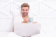 © be free - Man freelancer with coffee and laptop having video call at home in the bed