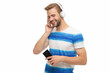 © be free - Millennial man listening to music in headphones. Man with headphones using phone. Generation z guy use phone application for training or music. Modern phone with wireless headphones isolated on white