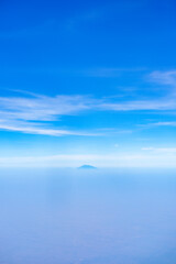 Wall Mural - view of the bright blue sky and mountains on the island of Java from the plane window, blue sky with clouds, See Through Plane Window With Blue Sky And Clouds Outside, travel trip over Java island