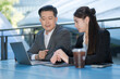 © Naypong Studio - Business professionals working outdoors with laptop