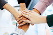 © S K Tu Mai - Close-up top view of young business team people putting their hands together background with  business graph