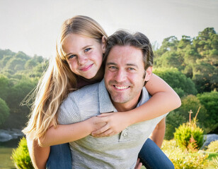 Wall Mural - father man hugging with girl child teen daughter outdoor in nature on sunny day piggyback