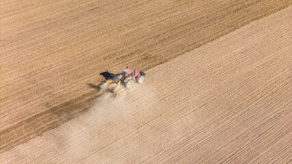 Wall Mural - Tractor working in agriculture fields, aerial drone view
