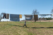 © Cavan Images - Boy running in the shadows of sheets hanging on a clothesline