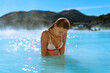 © Cavan Images - Woman relaxing in hot spring Blue Lagoon, Iceland.
