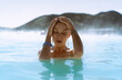 © Cavan Images - Woman relaxing in hot spring Blue Lagoon, Iceland.
