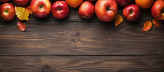 Wall Mural - A top view shows a rustic wooden table adorned with ripe red apples and raw orange pumpkins offering plenty of copy space