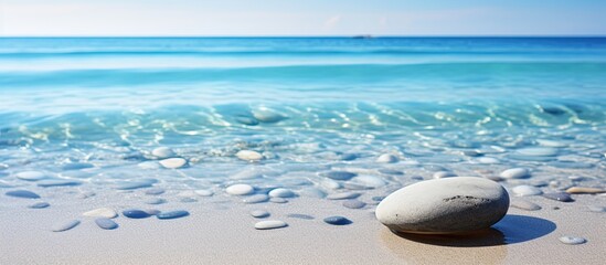 Sticker - A pebble resting in the clear water on the sandy beach creating a serene and natural background for any desired content Copy space image