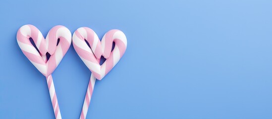 Aufkleber - High quality photo of white and blue heart shaped candy canes on a pink background with ample copy space