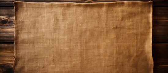 Fototapete - A brown burlap cloth on a brown wood panel providing a rustic backdrop for packaging or as a copy space image