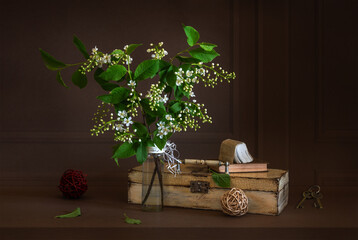 Wall Mural - A small bouquet with blooming fragrant bird cherry and a box with a mini-book on it.