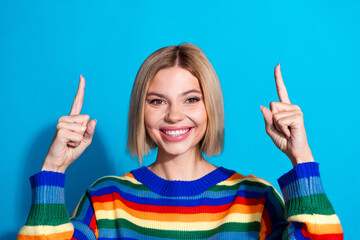 Poster - Portrait of pretty young girl point fingers up empty space wear striped pullover isolated on blue color background