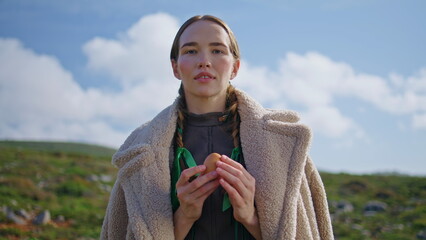 Woman holding fresh egg on green field. Healthy eating sustainable lifestyle