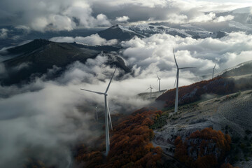 wind turbines on top mountain with clouds and fog