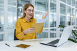 © Liubomir - Woman at office desk showing excitement while reading envelope. She has a laptop and tablet on her desk, surrounded by a modern office setting.
