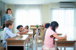 © Wosunan - Teacher and students, Learn and study in a classroom of school where youngsters sit and listen attentively.