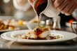 © studioworkstock - Chef pouring sauce over a beautifully plated fish dish garnished with fresh herbs, highlighting fine dining and culinary craftsmanship.