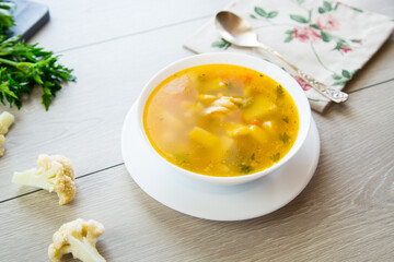 Wall Mural - Homemade chicken vegetable soup on rustic wooden background