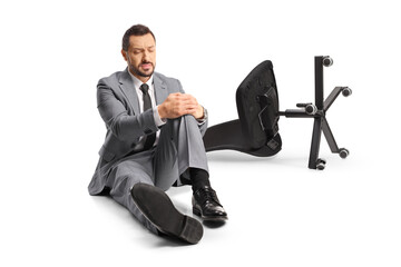 Wall Mural - Office chair on the ground and a businessman holding his painful knee