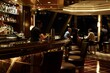 © studioworkstock - Elegant bar interior with a bartender preparing drinks and patrons seated at the counter and tables enjoying an evening out.