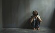 © Kartika - Lonely young boy sitting on the floor in the corner feeling unhappy in the dark room. Bullying, depression, scary concept.