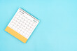 © gamjai - 2024 July Desk Calendar On Blue Background. Composition with copy space.