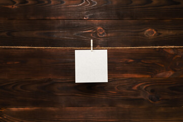 Sticker - paper card hanging on the rope on wooden background