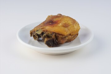 Wall Mural - pieces of fried chicken on a white plate on a white table with studio lighting