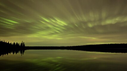 Wall Mural - a somewhat abstract time-lapse of nighttime clouds moving above a calm lake. the clouds are colored 