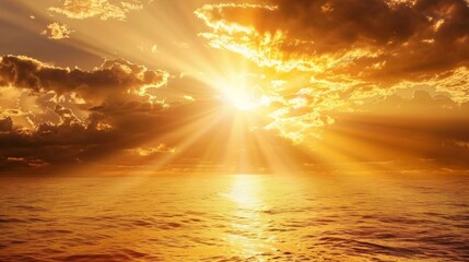 Wall Mural - The sun breaks through the clouds casting a brilliant beam of light down onto the ocean creating a golden path.